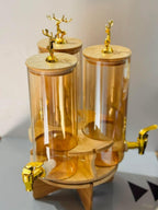 Elegant Triple Section Glass Beverage Dispenser with Gold Deer Lid, Wooden Stand, Round Design, Perfect for Gatherings.
